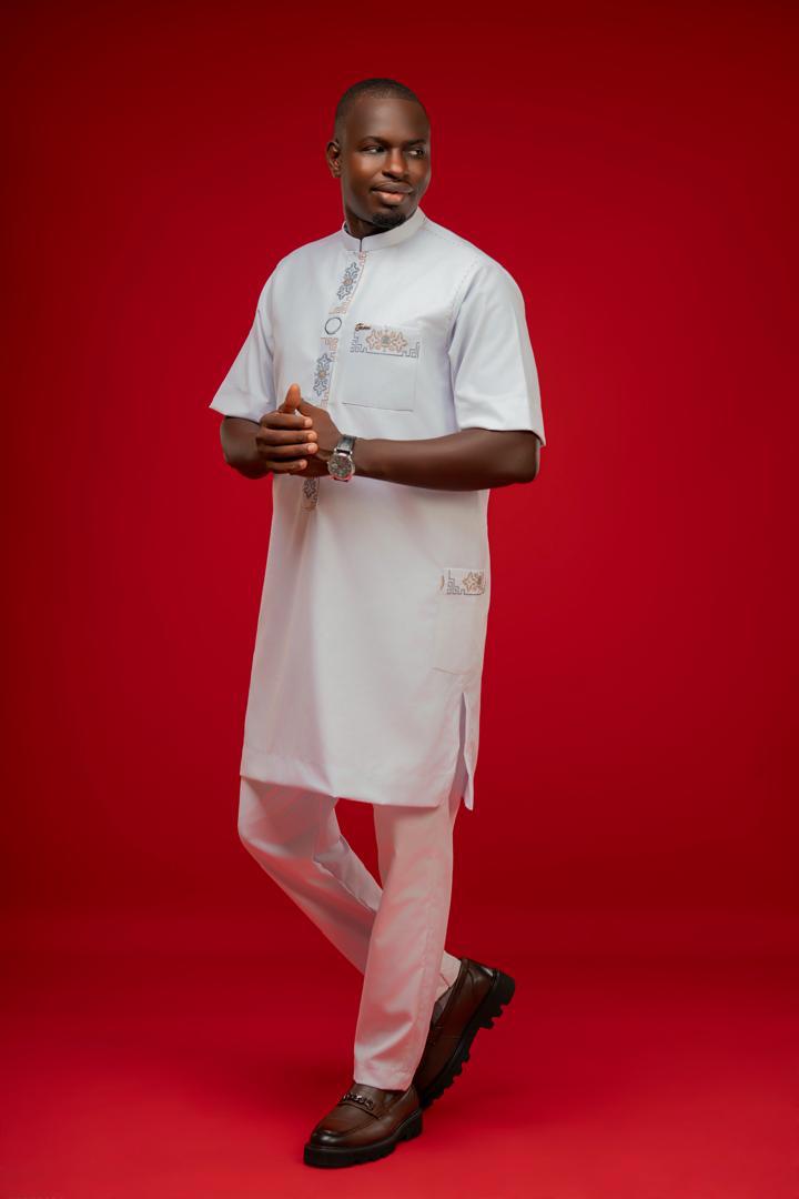Homme en ensemble blanc à manches courtes sur fond rouge