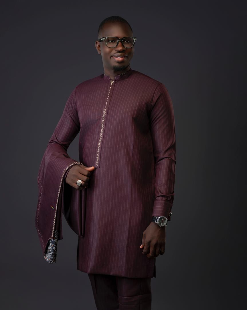Homme en grand boubou bordeaux à fines rayures et broderies dorées